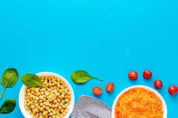 Vegetarian bowl with chickpeas and vegetables - blue table top view copy space