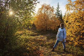 A woman in tundra enjoying scenery of colorful autumn in far north