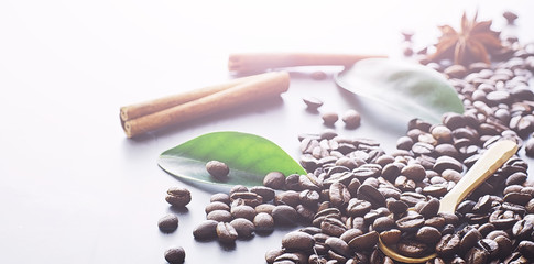 Coffee beans with green leaves for cooking. Bag of coffee. Coffee beans roasted on the table.