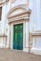 Fototapeta na wymiar Entrance of Catholic Church with Green Wooden Door 