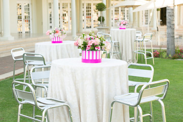 flowers in a pink candy vase, on a white cocktail table.