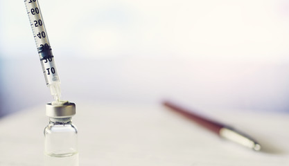 A man signs a medical document. Medical equipment on the table. Stethoscope and ampoules with syringes. Makes notes in the office. Medical center.