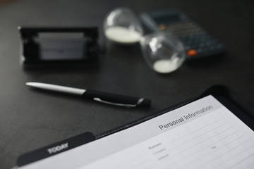 Filling out a form with personal information. Documents in a folder on the table to fill. Handwritten information about the applicant.