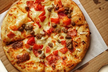 Pizza, close up photo of a delicious pizza with mozzarella cheese, onions, meat, tomato.