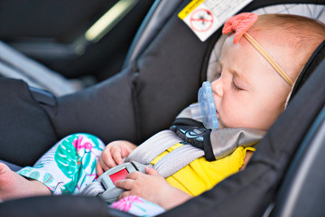 Little baby sleeping in a car in a child car seat