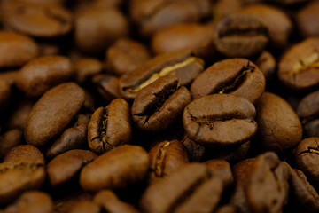 Coffee bean pile background closeup. Super macro coffee bean heap.