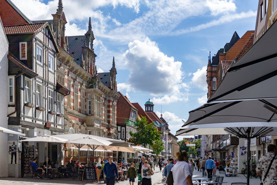 the market street in old town Hamelin with people enjoying a beautiful summer day