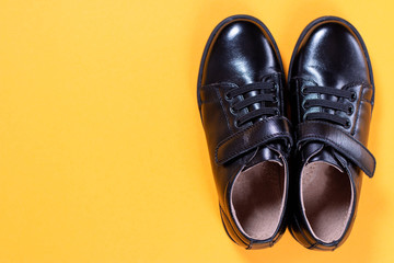 Black shoes and alarm clock on colored background. Flat lay, top view trendy background.