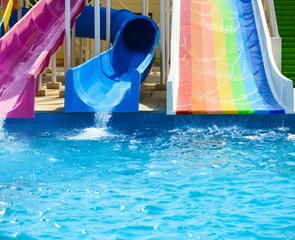 water sliding down in pool from summer aqua park sliders background