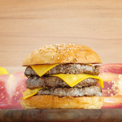 Fresh burger with cheese on wooden background