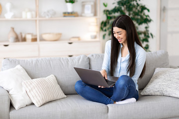 Online Education. Asian girl using laptop at home, having distance learning