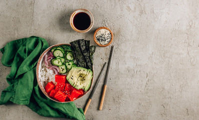 Hawaiian salmon poke bowl with seaweed, cucumber, avocado and sesame seeds.