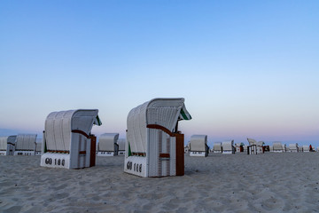 beautiful sunset and beach evening with white beach baskets on sandy beach