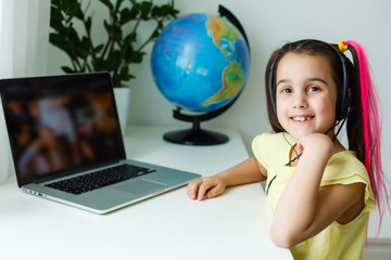 Cute little girl using laptop at home. Education, online study, home studying, distance learning, schoolgirl children lifestyle concept