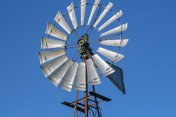 Windmill, with up to aluminum, behind the blue sky.