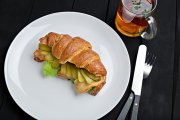 Sandwich croissant in plate for breakfast close up