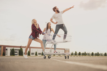 Confident hipster standing in trolley near girlfriends