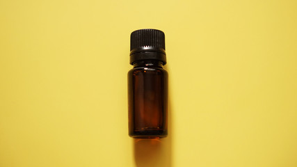 The bottle of cosmetic oil on the yellow background