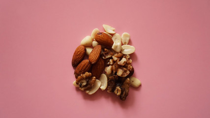 A handful of nuts on a bright pink background, color background