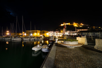 Fototapeta na wymiar Tuscany Maremma Castiglione della Pescaia, fireworks over the sea, panoramic night view of the port and the castle
