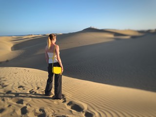 Jeune femme devant des dunes de sable désertique