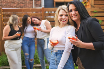 happy girl friends drinking drink having fun outside