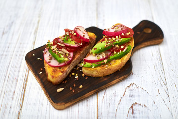 Toasts with vegetables, avocado, tomatoes, a set of seeds on a white background. Healthy food, diet concept.