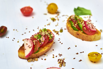 Toasts with vegetables, avocado, tomatoes, a set of seeds on a white background. Healthy food, diet concept.