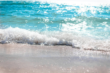 Beautiful scenery of sea waves lapping on the shore of the beach on sunny day
