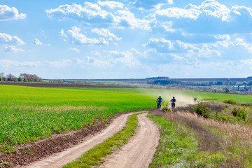 Motorcycle racing on a country dusty road 