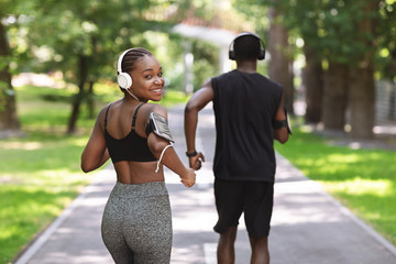 Wellness Concept. Smiling African Girl Jogging With Her Boyfriend In City Park
