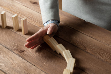 Business woman hand stop domino effect