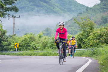 Fototapeta premium Cyclists in mountain. Biking travel tour on rural road at Suan Phueng district, Ratchaburi, Thailand.