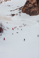 skiers and snowboarders descend from the ski slope