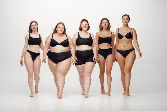 Inclusion. Portrait of beautiful young women with different shapes posing on white background. Happy female models. Concept of body positive, beauty, fashion, style, feminism. Diversity.