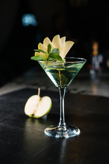 Making cocktails at home like an expert nightclub barman. Fresh and juicy colorful homemade beverages garnished with apple.