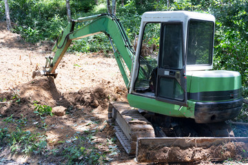 Crawler excavator digging on mountain equipment for construction.
