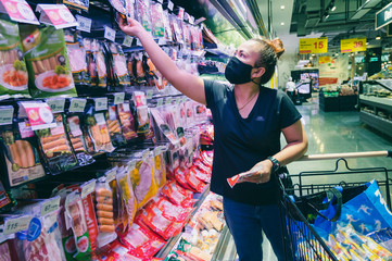 woman with mask shopping in supermarket 