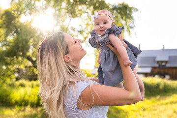 Obraz premium Happy mother with little daughter spending time together in sunny field