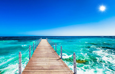 wooden bridge juts out into  of the sea