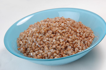 groats in plate on white