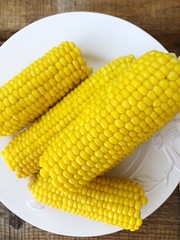 Boiled corn on a white plate macro
