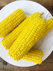 Boiled corn on a white plate macro