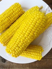 Boiled corn on a white plate macro