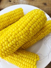 Boiled corn on a white plate macro