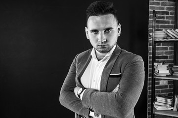 young attractive business man showing blank copy space over palm for customer to add item or text, looks happy and excited, isolated on dark background in white shirt