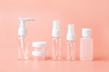 Set of empty travel women toiletries beauty kit on beige orange background. Approved for airplane luggage bottle container size. Isolated with copy space for text for beauty social media