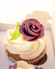 Closeup of tasty homemade cupcakes with sugar icing in paper box