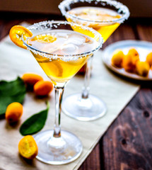 cocktail with kumquat on wooden background