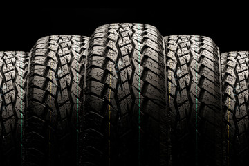 Off-road tires close-up on a black background, displayed in a row